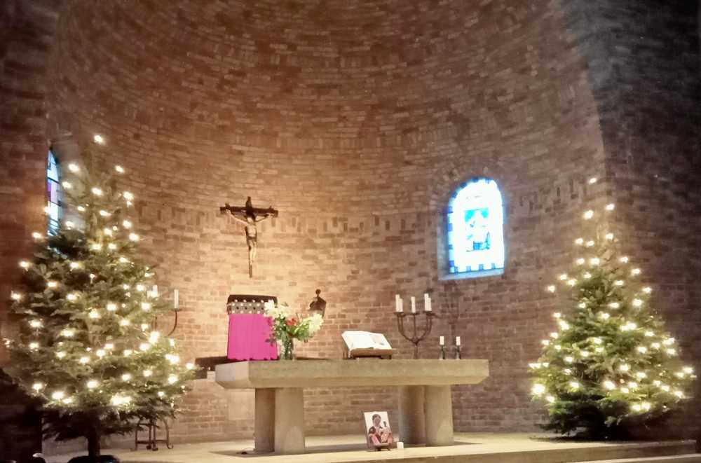 Zicht op priesterkoor met kerstbomen en altaar, 2021
